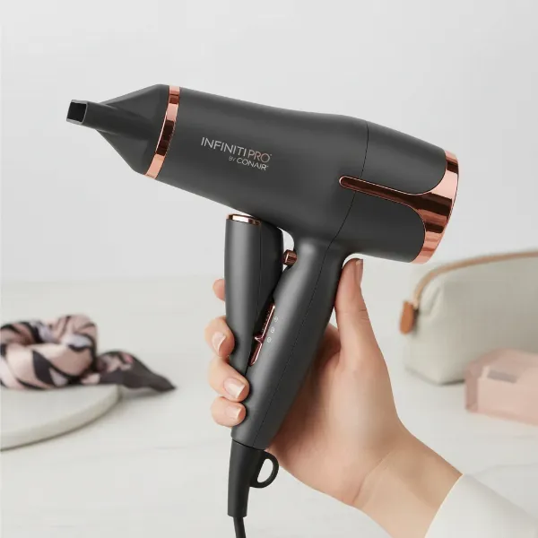 Lightweight, compact, and ergonomically designed Conair Infiniti Pro hair dryer, possibly folded for travel.